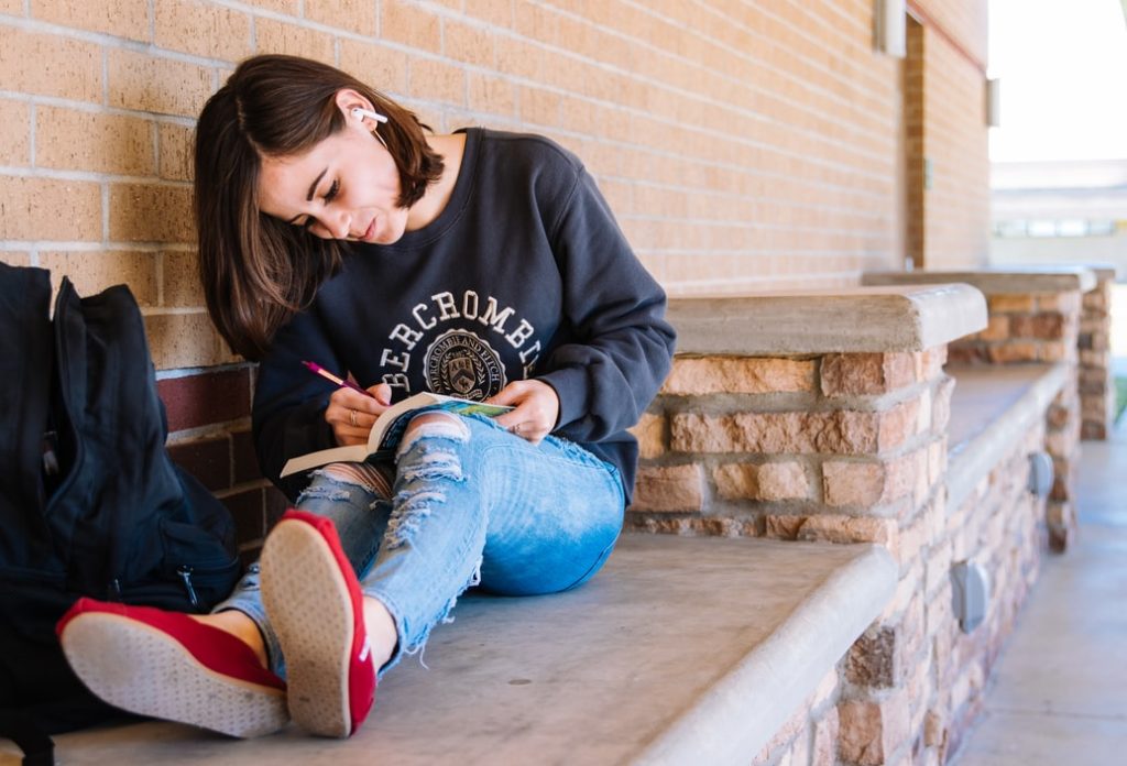 teen writing in a journal after attending a teen therapy session