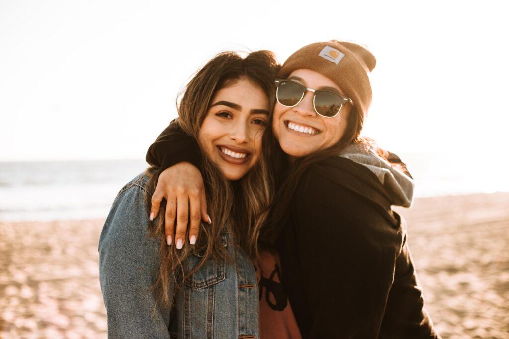 two teen girls on the beach smiling after finding healing in teen therapy