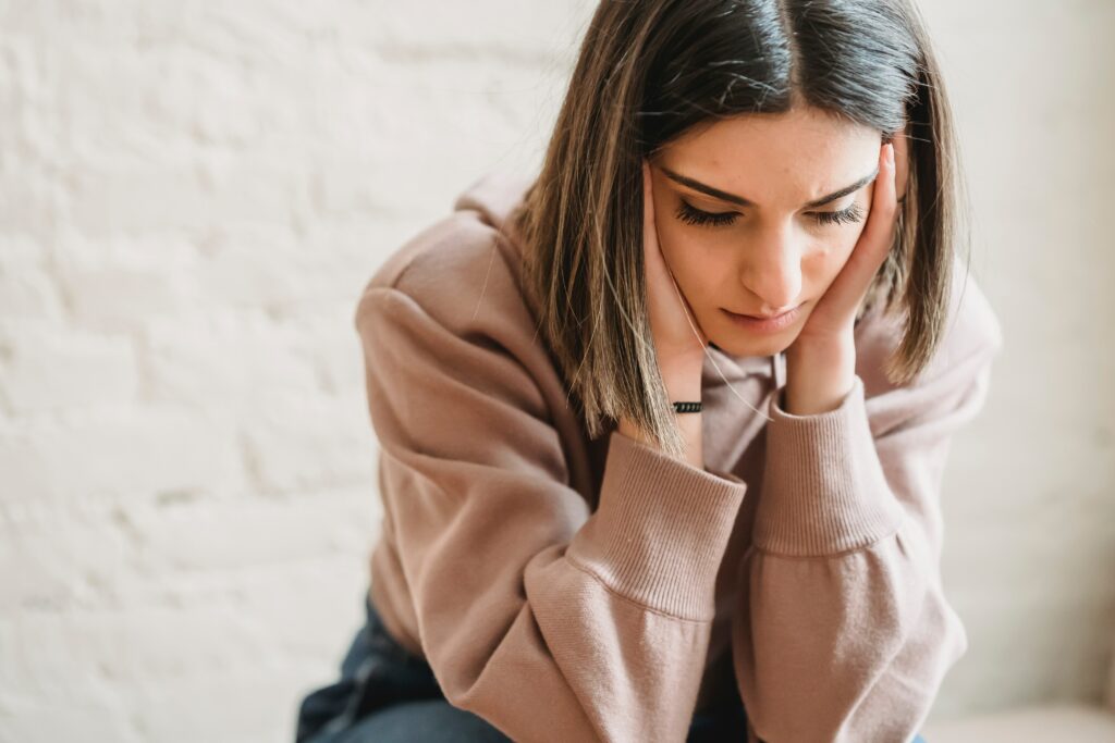 Woman dealing with anxious thoughts, sitting in room