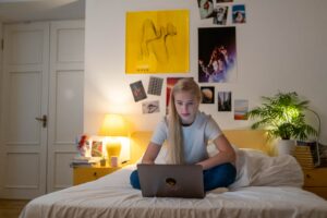 Young Girl sitting in her room in front of laptop