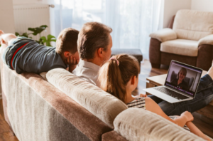 Family (two teens and their father) in a telehealth therapy session skills group. 