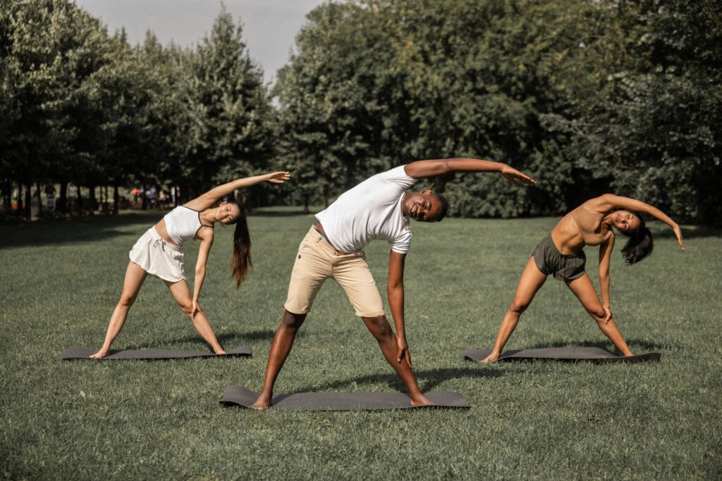 3 people finding holistic balance in yoga outdoors