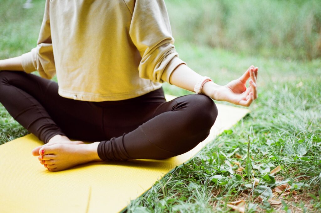 a woman on a New Jersey beach in a yoga pose working towards holistic healing