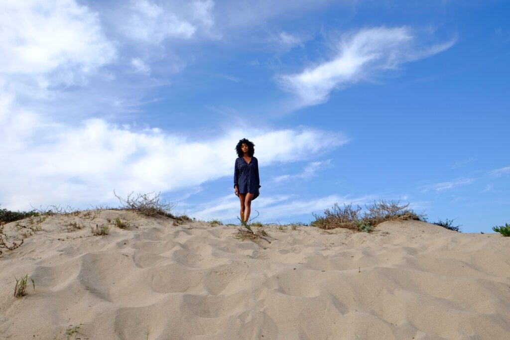 black woman standing on a New Jersey beach thinking about self-acceptance and healing from trauma