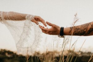 two hands reaching out to each other as two people struggle with their relationship due to unprocessed trauma