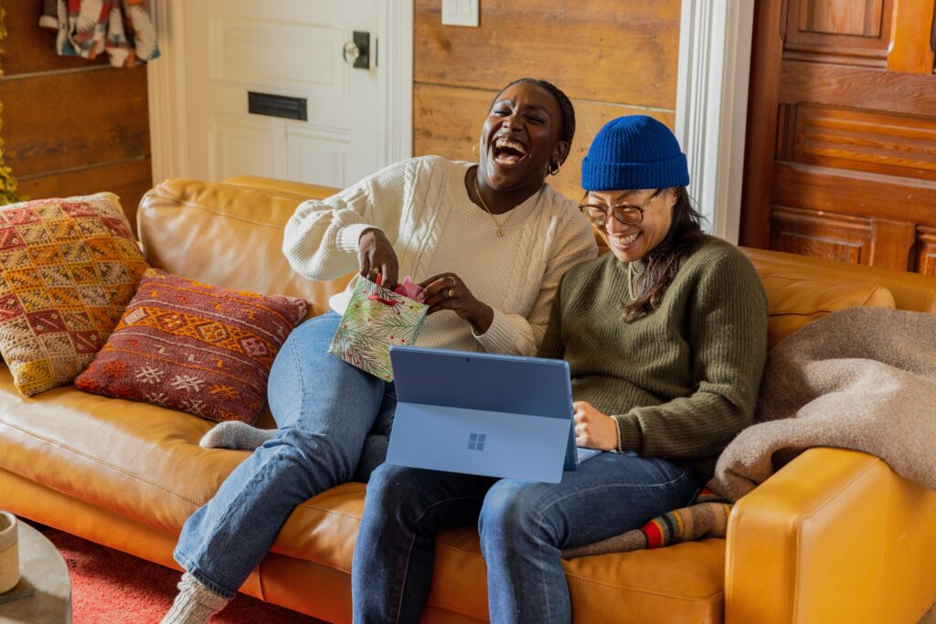 two people laugh on a couch as they enjoy their relationship after trauma healing