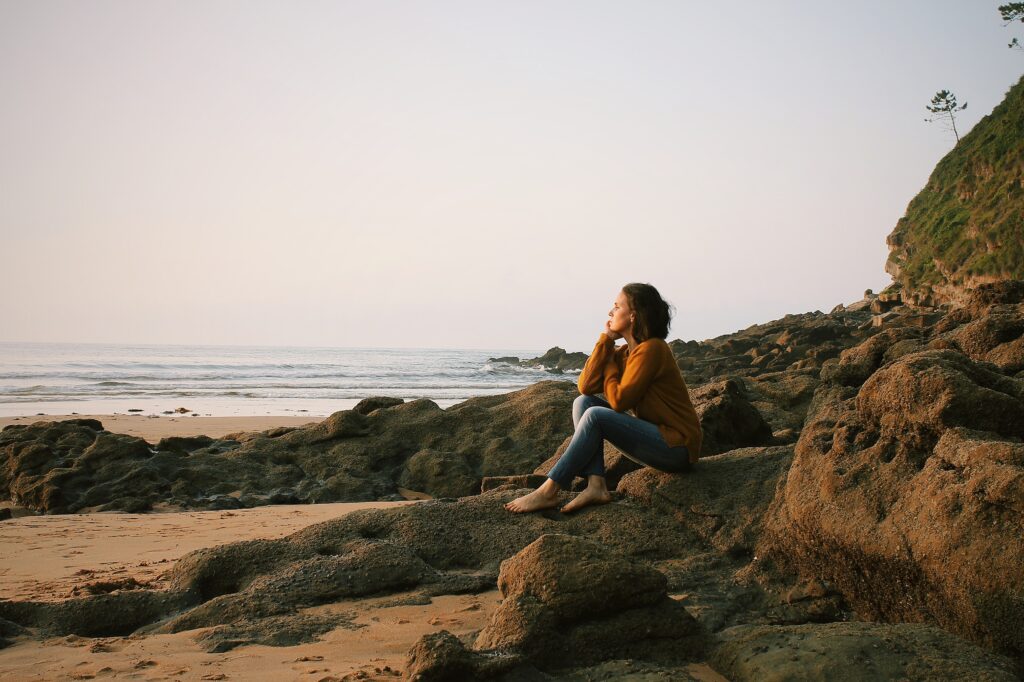 woman on a beach contemplating holistic healing and neuroplasticity