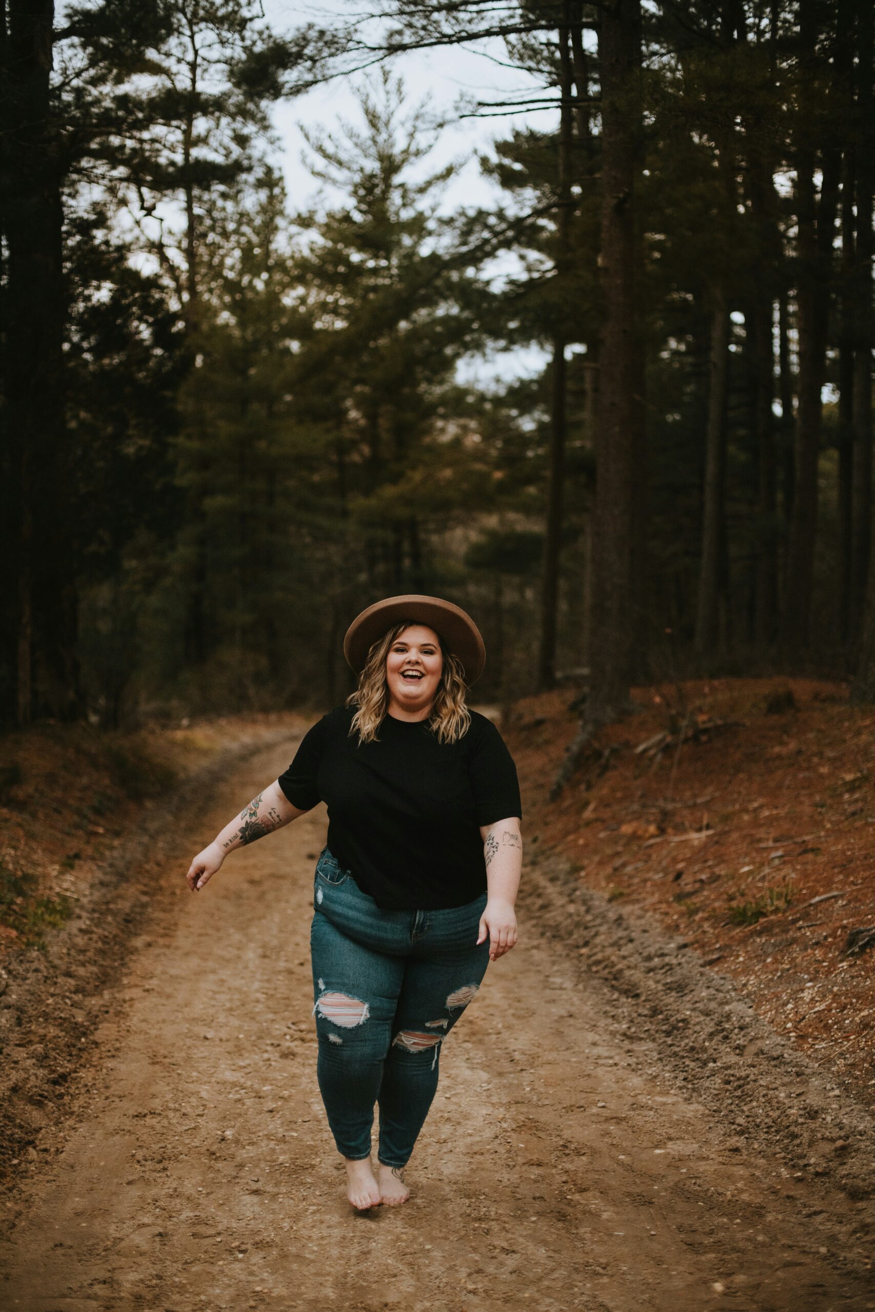 smiling woman walking down a path thinking about the mind-body connection and goal setting