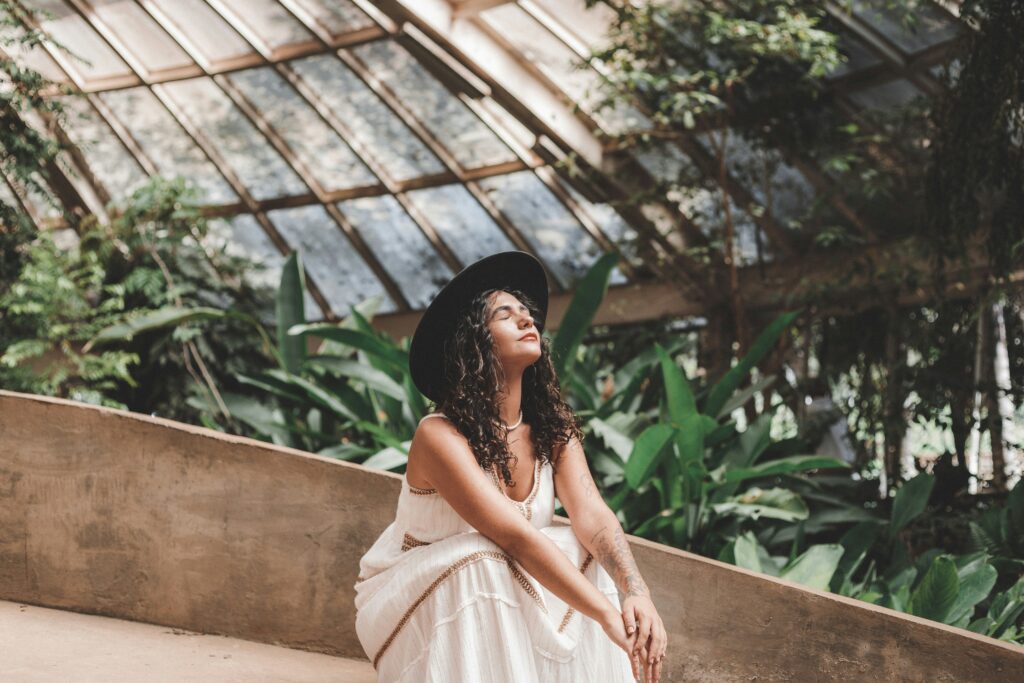 woman in a greenhouse thinking about reaching her goals with therapy