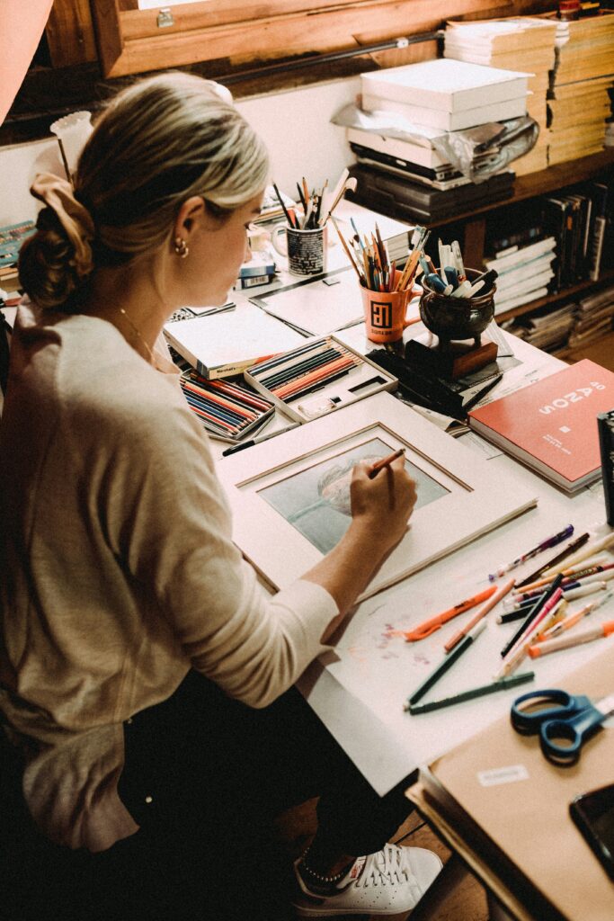 A woman using art as a healing tool, exploring the healing potential of art as instructed by the therapists at Awakened Path.