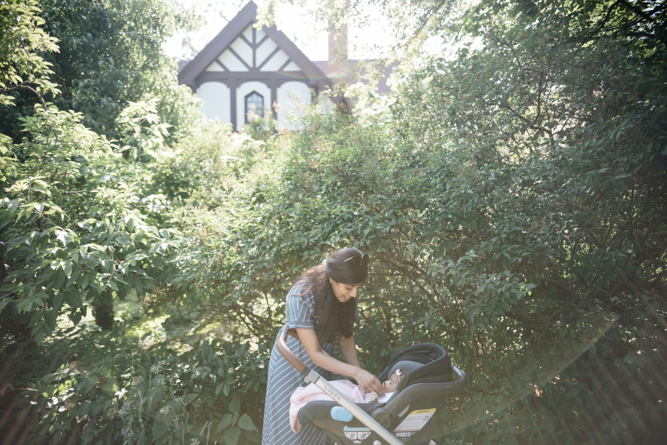 woman outside with her baby in a stroller during postpartum recovery