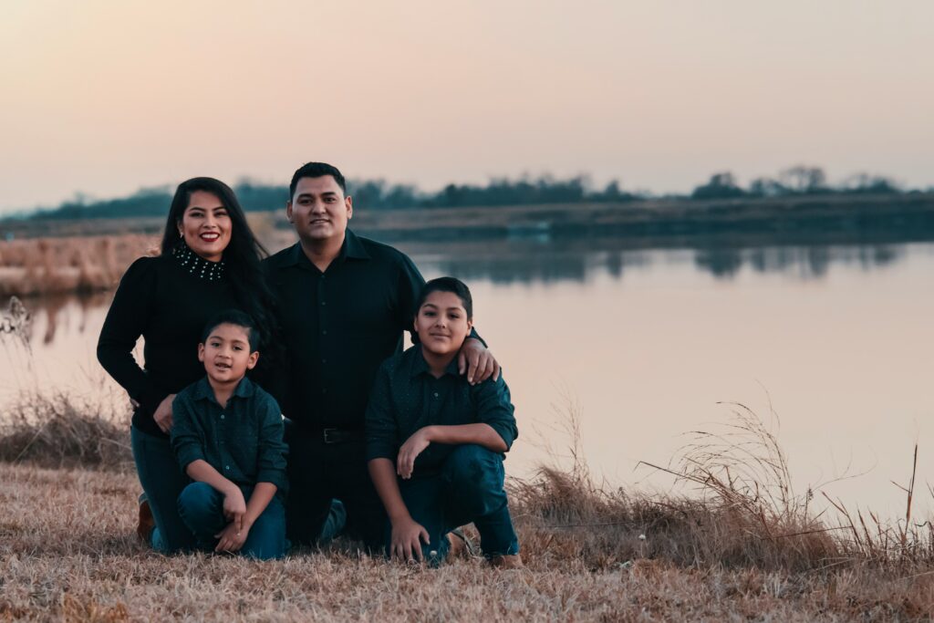 family posing together on a beach after healing in family therapy