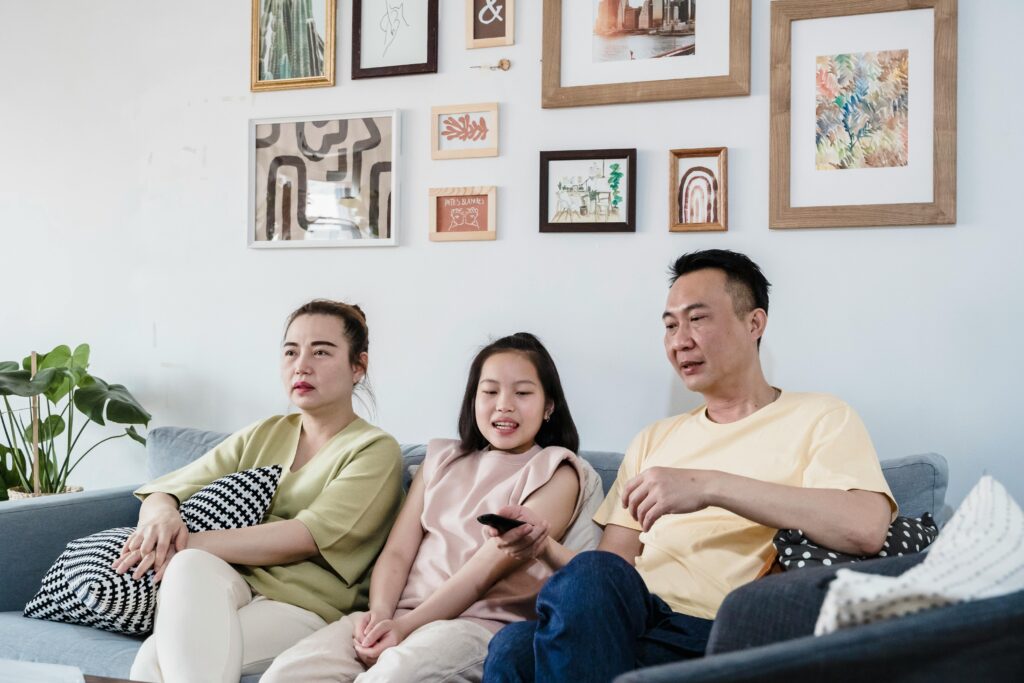first generation immigrant parents with their daughter trying to connect and bond as a family while watching tv