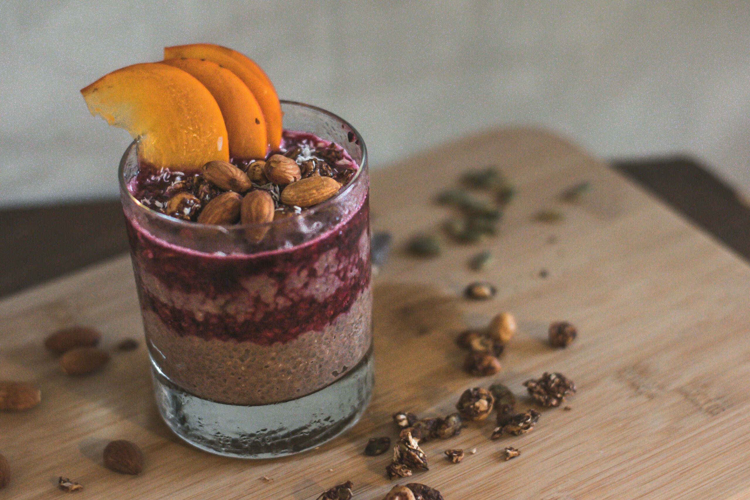 Berry smoothie bowl topped with almonds, seeds, and fruit, showcasing whole-food fats that promote good fats mental health and stabilize mood.