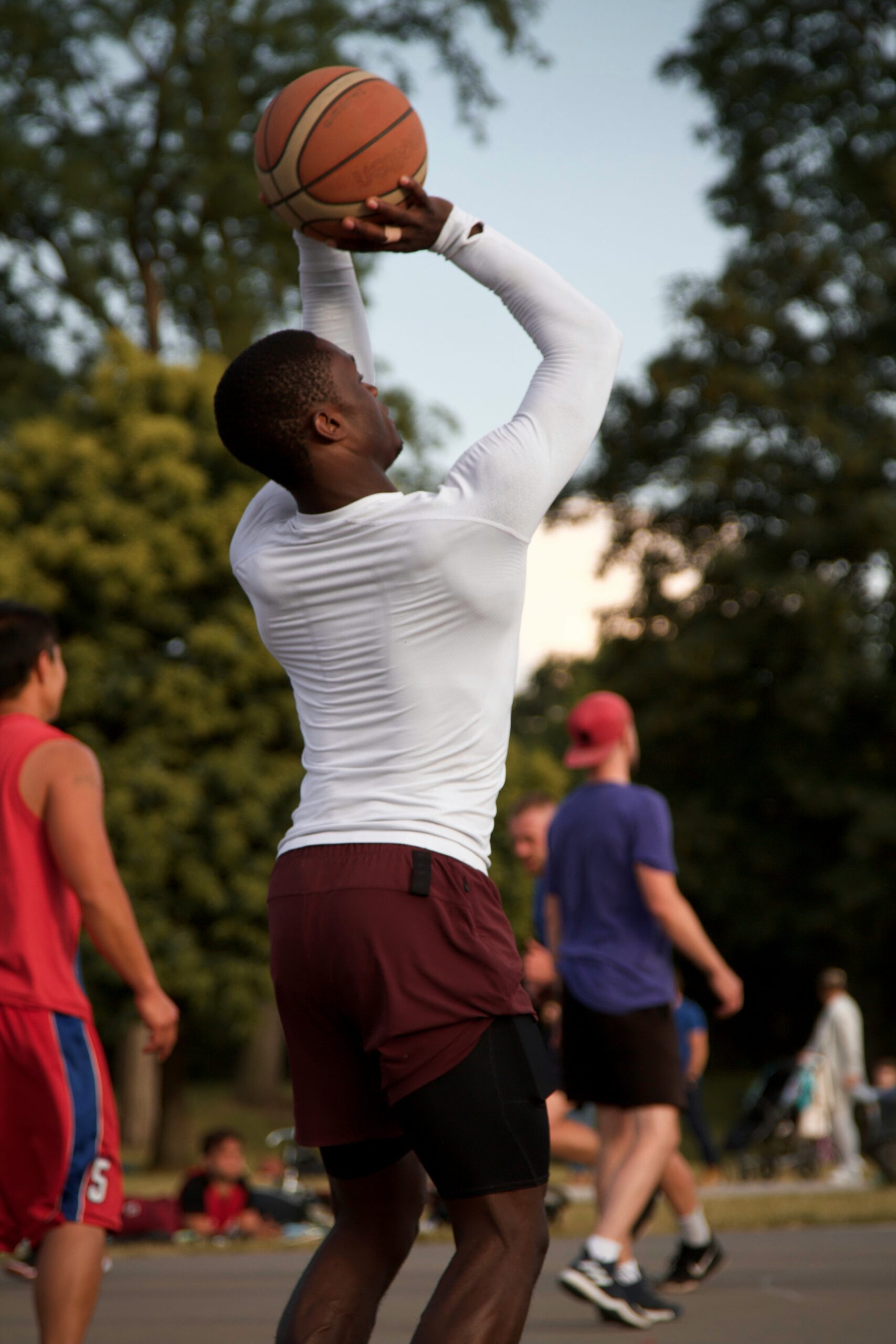 Man playing basketball outdoors as a form of functional fitness supporting mental health, brain health longevity, and active lifestyle habits