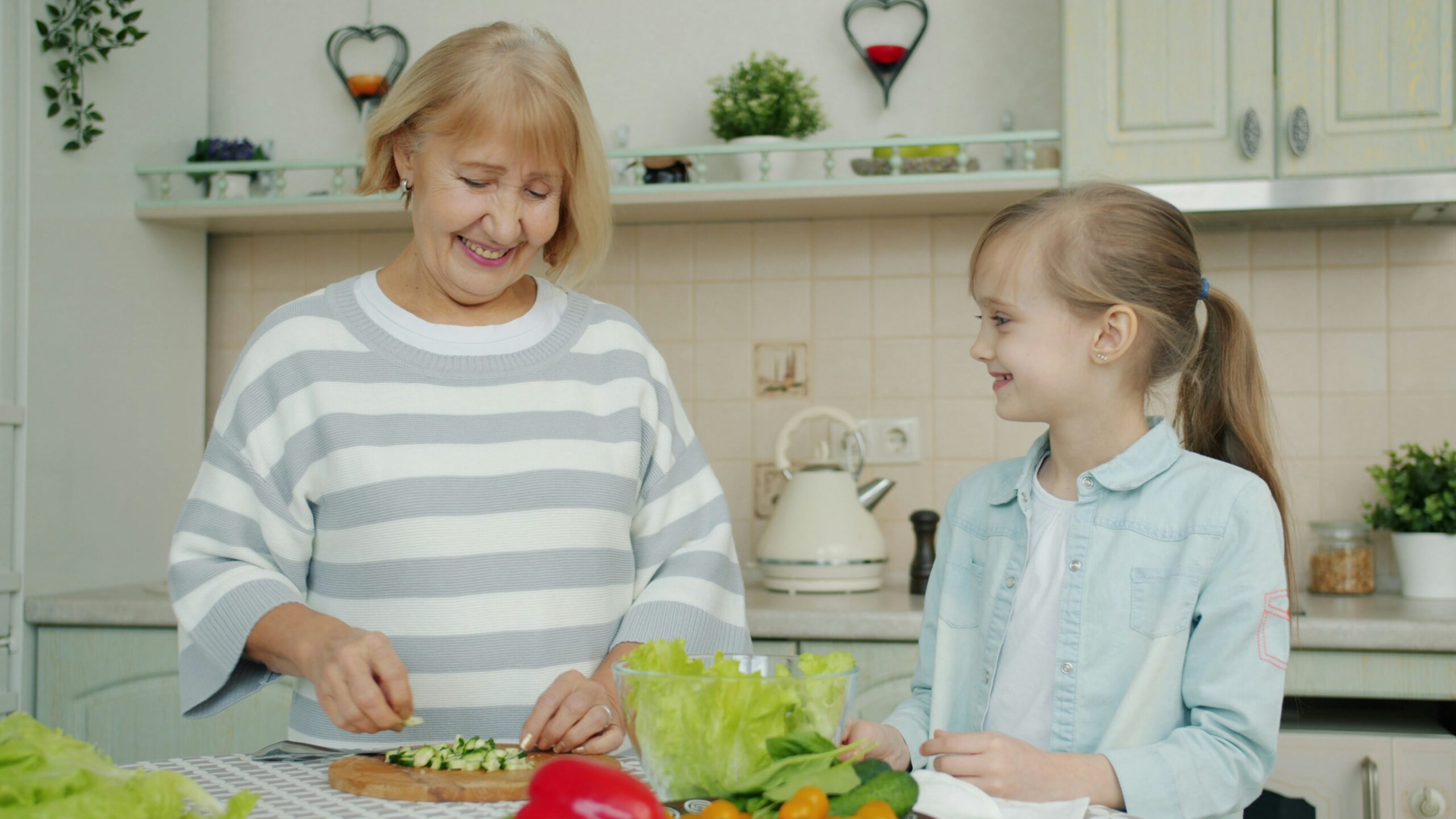 Grandmother and child preparing fresh vegetables together in a kitchen, supporting nutrition for brain health and emotional connection across generations